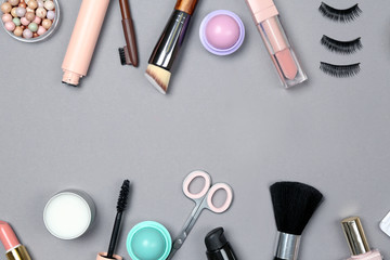 Set of makeup cosmetics with accessories on grey background