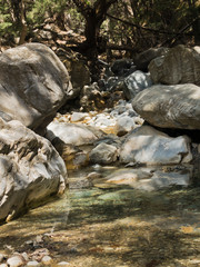 Crystal clear water of a cold mountain creek at rocky terrain of Samaria gorge, south west part of Crete island, Greece