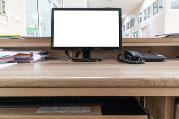 Monitor computer with blank screen on wooden desk in office.