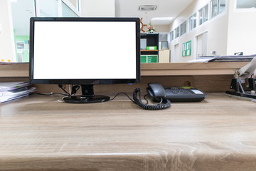 Monitor computer with blank screen on wooden desk in office.