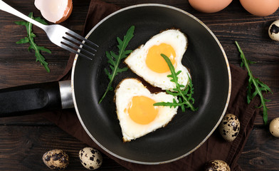 Valentines breakfast in heart shaped cast iron pan of two raw eggs and yolks