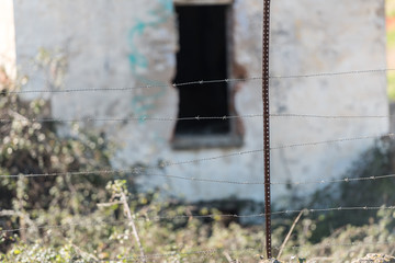 Barbed wire surrounding an old abandoned house in Caceres, Extremadura, Spain.