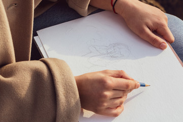 Hands of a girl while drawing a cartoon