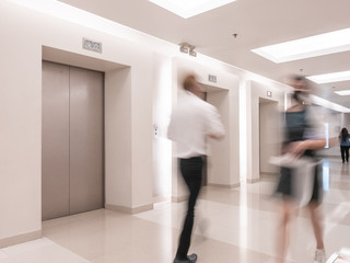 People are walking in office past elevators, Modern steel elevator cabins in a business lobby or Hotel, Store, interior, office,perspective wide angle