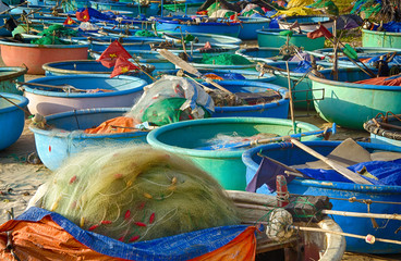 Vietnamese fishing boats on the sandy beach. In the foreground is a fishing net. Asia, Vietnam, Mui Ne, Phan Thiet.