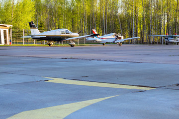 Light passenger planes parked before departure at private airport in Kronshtadt, St.Petersburg, Russia. Industrial and civil air transportation by aircraft. Professional flights on airplanes