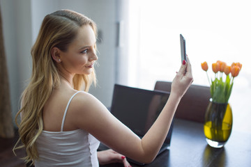 Young woman video calling on smartphone at home