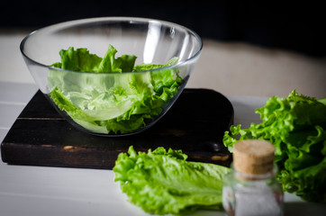 Man is preparing green salad of romaine lettuce. Healthy food concept