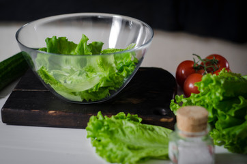 Man is preparing green salad of romaine lettuce. Healthy food concept