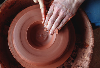 Professional potter making bowl in pottery workshop, studio