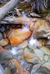 Clear creek water cascades over colorful river stones make abstract pattern in South mineral creek river stones along the Rico Silverton trail in the San Juan range of the Colorado Rockies.
