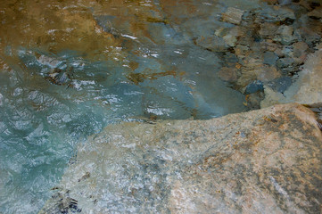 Abstract image created by rippled water and multi-colored rocks in South Miineral Creek in the San Juan Rockies of Colorado