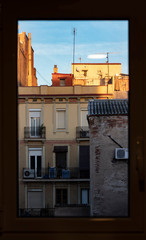 View of Barcelona street from the window in the morning. The photo has a window frame.