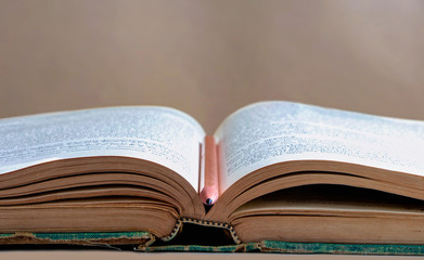 Open hardback and textbook on the table on blackboard background. The concept of intelligence comes from education. focused on the textbook.