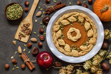 pumpkin pie with nuts, pumpkin seeds and Apple on dark background