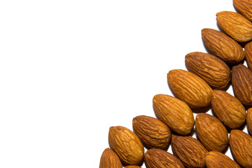 Close-up of almonds. Almonds in the corner. From the side. On white background. Isolated.