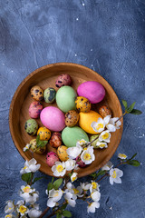 Easter quail eggs in a wooden plate