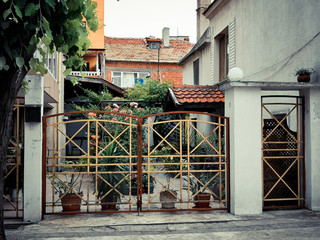 Fototapeta na wymiar beautiful cute yard with a metal fence flowers on a quiet street Pomorie region Burgas in Bulgaria