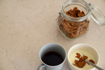 Cup of coffee and wholegrain cereal and yoghurt in a bowl