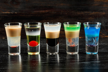Alcoholic cocktail row on bar table, colorful party drinks