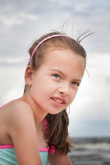 Uśmiechnięta dziewczynka na plaży - obrazy, fototapety, plakaty