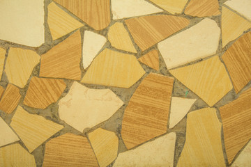 yellow white gray broken pieces of ceramic tile in cement. rough surface texture mosaic