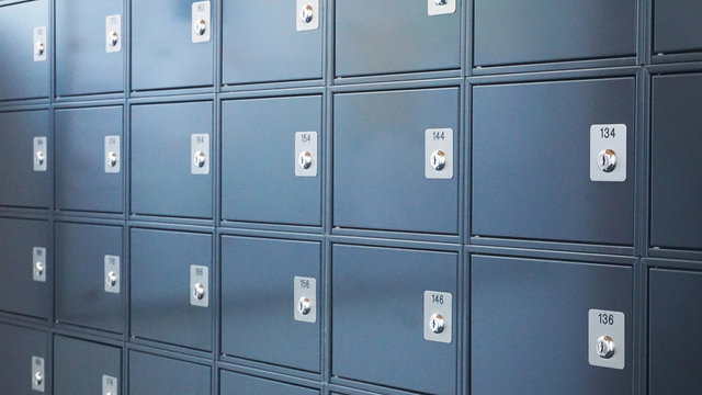 Metallic modern mailboxes lockers in gray-blue colors in a row at the entrance of a business center or at the entrance to a residential building