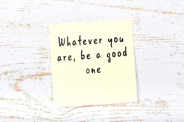 Positive inspiring quote handwritten on sticky note on wooden background