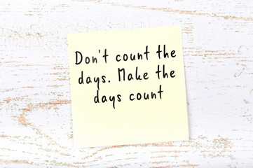 Positive inspiring quote handwritten on sticky note on wooden background