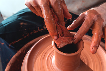 Hands working on pottery wheel