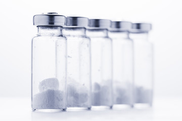 Bottles for injection with white powder on a white background