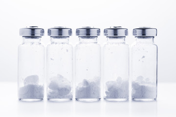 Bottles for injection with white powder on a white background