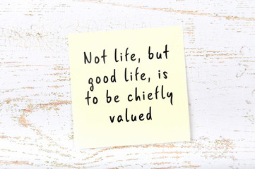 Positive inspiring quote handwritten on sticky note on wooden background