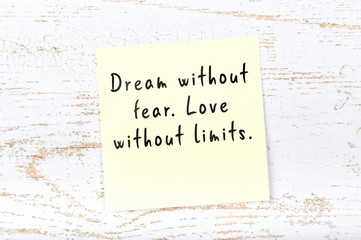Positive inspiring quote handwritten on sticky note on wooden background