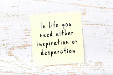 Positive inspiring quote handwritten on sticky note on wooden background