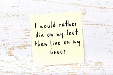 Positive inspiring quote handwritten on sticky note on wooden background