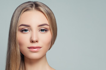 Beautiful woman face closeup. Perfect blonde girl with long healthy hair and clear skin. Facial...