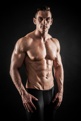 Fototapeta na wymiar Athletic shirtless young male fitness model posing