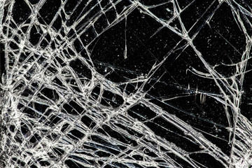 white cracked glass with dust on black background, texture