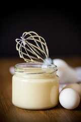 homemade mayonnaise in a glass jar on a wooden
