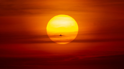 Silhouette of airplane in sunset landing on airport