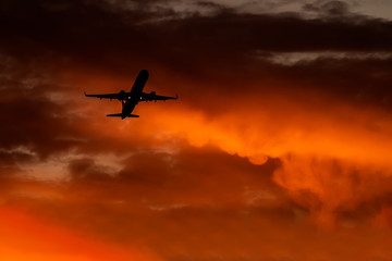 Fototapeta na wymiar Airplane silhouette at sunset time 
