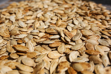 Fried pumpkin seeds lying on the old rustic background. Vegetarian superfood. Healthy diet. Natural texture background.