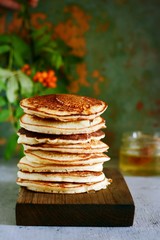 A stack of lush punkcakes for breakfast on a gray background. High pile of delicious pancakes with berries.American Cuisine, Copy space