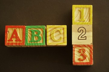 Colourful wooden cubes representing numbers and capital letters forming ABC, the first three letters of the Latin script known as the alphabet