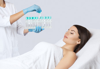 The doctor holds blood collection tubes in the cosmetology office before the Prp procedure.