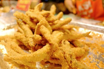 A pile of fried Shishamo fish on a tray and selling at the night market in Thailand