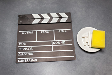 Movie clapper board with chalk and sponge on gray background