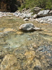 Crystal clear water of a cold mountain creek at rocky terrain of Samaria gorge, south west part of...