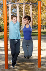 Obraz premium Family doing exercises on horizontal bar
